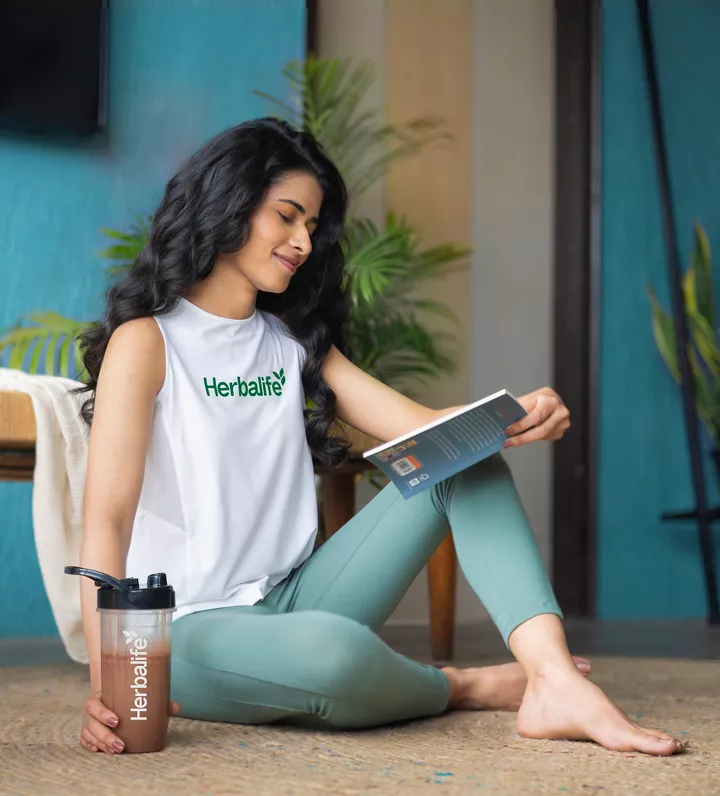 woman reading book holding shaker chocolate shake